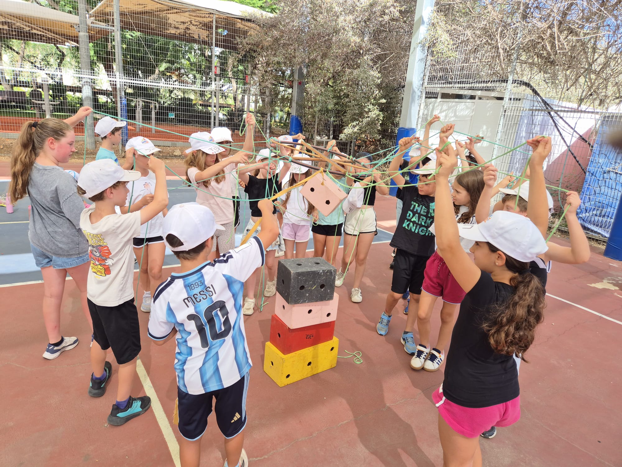 ילדים משתפים פעולה בהרמת קוביות באמצעות חבלים בפעילות ODT של תנופה